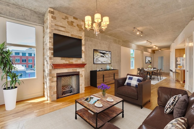 417 Frazier Ave Unit 404, Chattanooga, TN 37405 - living room featuring light wood-style flooring, healthy amount of natural light, a chandelier, and a stone fireplace