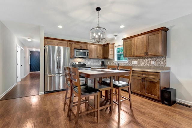 200 Woodsong Ln, Columbia, TN 38401 - kitchen featuring stainless steel appliances, a chandelier, wood finished floors, decorative backsplash, and recessed lighting