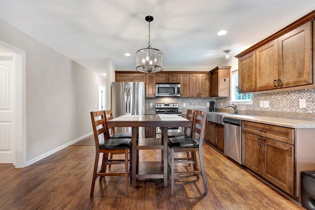 200 Woodsong Ln, Columbia, TN 38401 - kitchen with appliances with stainless steel finishes, tasteful backsplash, a chandelier, dark wood-style flooring, and recessed lighting
