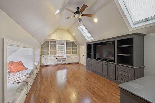 103 Wellesley Pl, Columbia, TN 38401 - unfurnished living room with a skylight, vaulted ceiling, a ceiling fan, built in shelves, and light wood finished floors