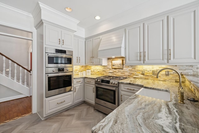 103 Wellesley Pl, Columbia, TN 38401 - kitchen featuring stainless steel appliances, custom exhaust hood, light stone counters, crown molding, and tasteful backsplash