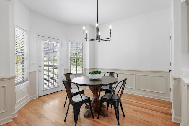 9401 Lazy Circles Dr, Ooltewah, TN 37363 - dining area with a chandelier, a wainscoted wall, light wood-type flooring, and a decorative wall