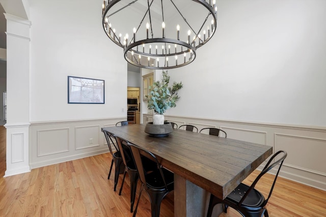 9401 Lazy Circles Dr, Ooltewah, TN 37363 - dining area featuring wainscoting, a decorative wall, light wood-style floors, and a chandelier