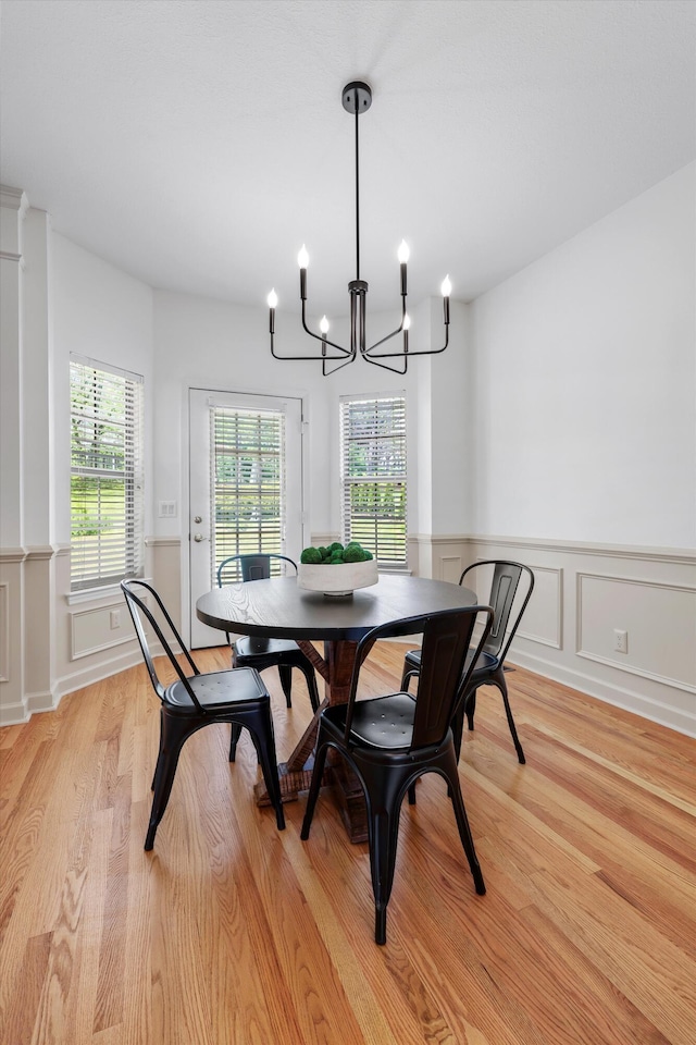9401 Lazy Circles Dr, Ooltewah, TN 37363 - dining area with light wood-style flooring, a chandelier, wainscoting, and a decorative wall