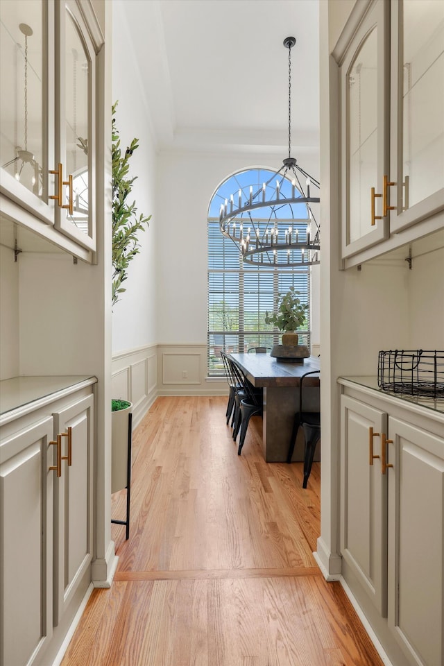 9401 Lazy Circles Dr, Ooltewah, TN 37363 - dining space with light wood finished floors, a chandelier, a decorative wall, and wainscoting