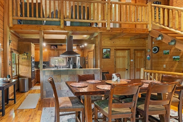 539 Bland Hollow Rd, Hohenwald, TN 38462 - dining area featuring wooden walls, light wood-style flooring, and a towering ceiling