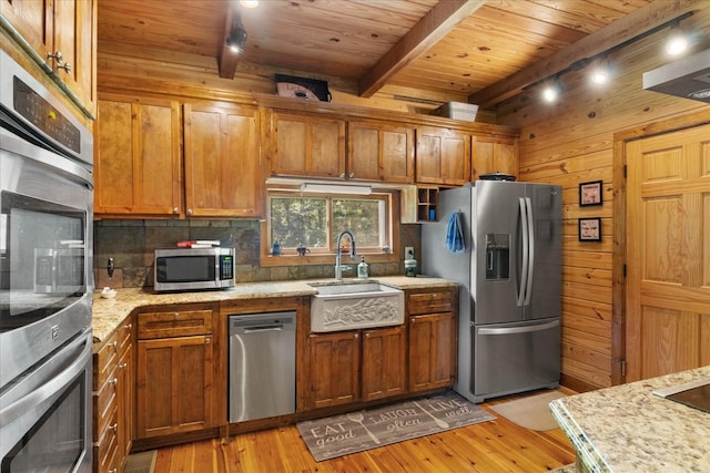 539 Bland Hollow Rd, Hohenwald, TN 38462 - kitchen featuring appliances with stainless steel finishes, tasteful backsplash, light wood finished floors, a wooden ceiling with exposed beams, and brown cabinetry