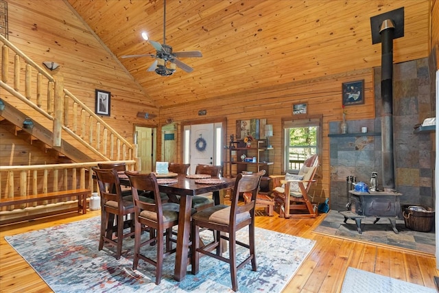 539 Bland Hollow Rd, Hohenwald, TN 38462 - dining area featuring a wood stove, wood walls, stairs, hardwood / wood-style floors, and ceiling fan