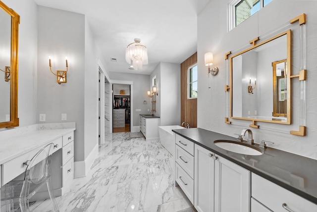 6004 Pelican Way, College Grove, TN 37046 - bathroom with two vanities, a spacious closet, a freestanding tub, a chandelier, and healthy amount of natural light
