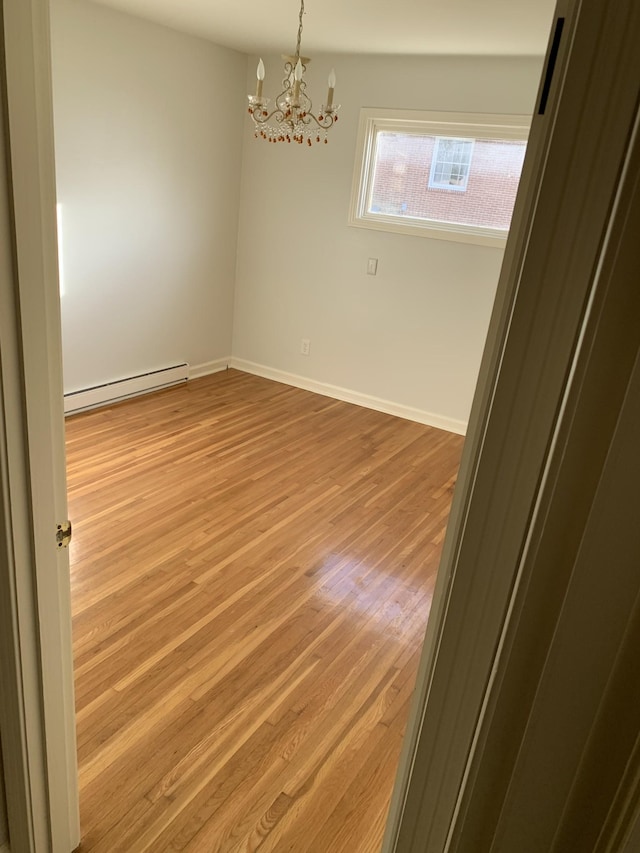 1206 Park Mere Dr, Columbia, TN 38401 - empty room with a baseboard heating unit, light wood-type flooring, and a chandelier
