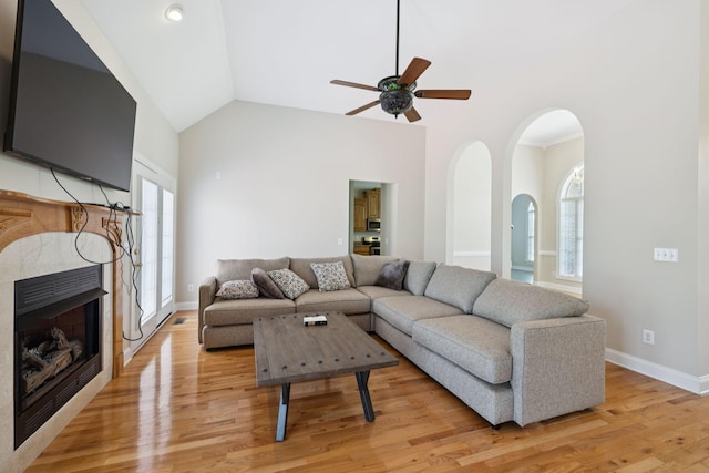 6913 Zion Crossing Ct, Columbia, TN 38401 - living room with a ceiling fan, light wood finished floors, arched walkways, a tile fireplace, and high vaulted ceiling