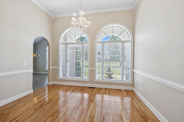 6913 Zion Crossing Ct, Columbia, TN 38401 - empty room featuring a chandelier, arched walkways, wood finished floors, and ornamental molding