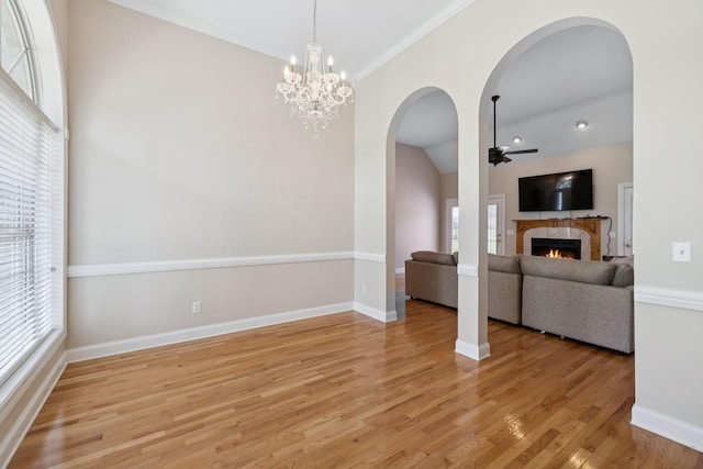 6913 Zion Crossing Ct, Columbia, TN 38401 - unfurnished living room featuring light wood finished floors, a premium fireplace, arched walkways, ceiling fan, and a chandelier