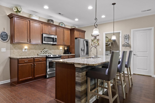 7560 Hampstead Hall Dr, Ooltewah, TN 37363 - kitchen featuring appliances with stainless steel finishes, crown molding, tasteful backsplash, an island with sink, and a breakfast bar area