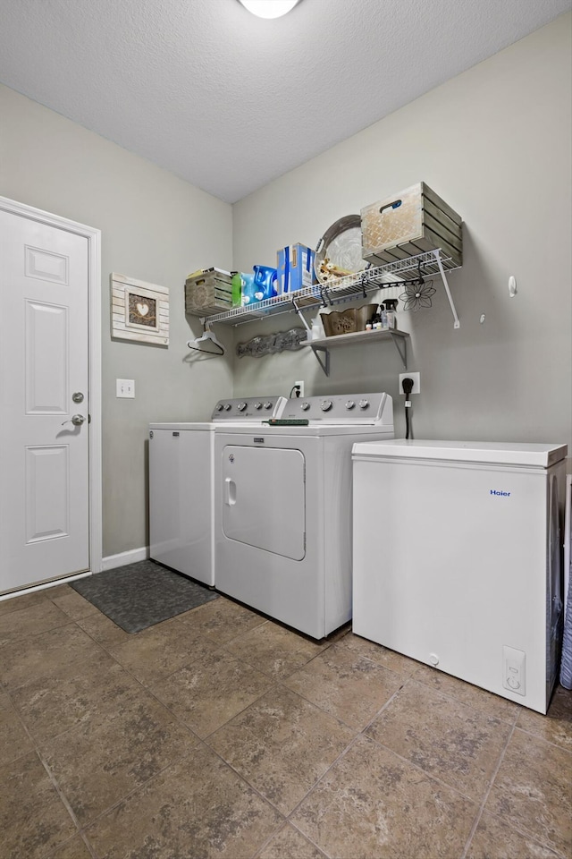 7560 Hampstead Hall Dr, Ooltewah, TN 37363 - laundry room featuring washer and dryer, a textured ceiling, and stone finish flooring