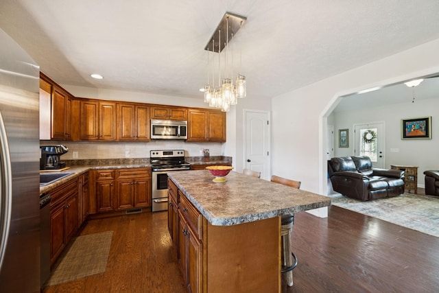 1493 Azalee Ln, Chapel Hill, TN 37034 - kitchen featuring appliances with stainless steel finishes, dark wood finished floors, brown cabinets, and a center island
