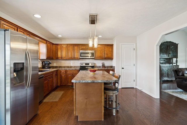 1493 Azalee Ln, Chapel Hill, TN 37034 - kitchen featuring stainless steel appliances, dark wood-style floors, brown cabinetry, a breakfast bar area, and recessed lighting