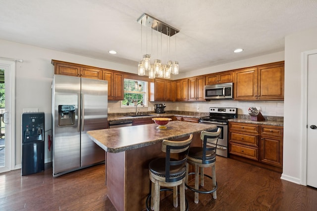 1493 Azalee Ln, Chapel Hill, TN 37034 - kitchen with appliances with stainless steel finishes, brown cabinetry, dark countertops, a center island, and dark wood-style floors