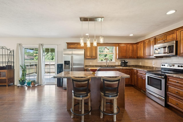 1493 Azalee Ln, Chapel Hill, TN 37034 - kitchen featuring appliances with stainless steel finishes, dark countertops, a center island, tasteful backsplash, and a kitchen bar