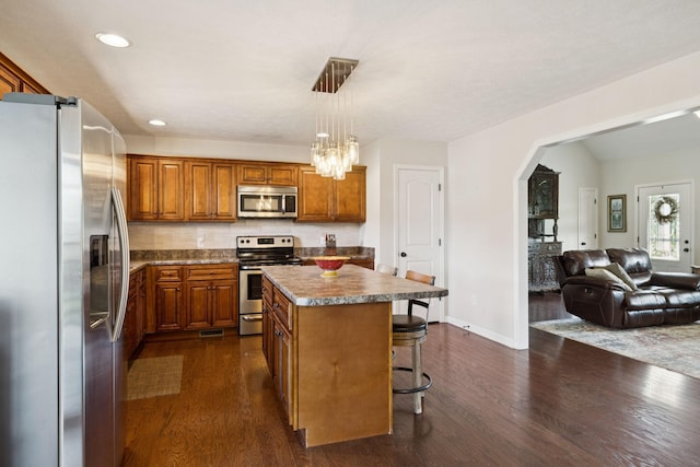1493 Azalee Ln, Chapel Hill, TN 37034 - kitchen featuring appliances with stainless steel finishes, brown cabinetry, open floor plan, dark wood-style flooring, and recessed lighting