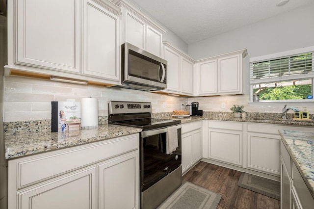1906 Charismatic Pl, Murfreesboro, TN 37128 - kitchen featuring appliances with stainless steel finishes, dark wood finished floors, light stone countertops, and backsplash