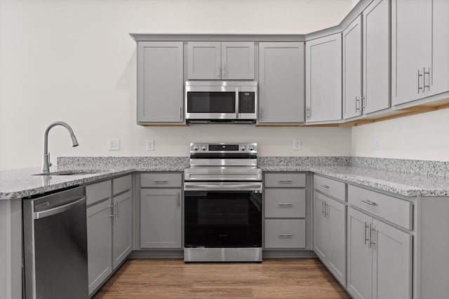 212 Mcbrien Rd, Chattanooga, TN 37411 - kitchen with stainless steel appliances, gray cabinetry, light stone counters, and a peninsula