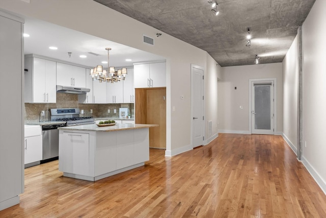 417 Frazier Ave Unit 303, Chattanooga, TN 37405 - kitchen with under cabinet range hood, appliances with stainless steel finishes, white cabinets, light wood-style flooring, and recessed lighting