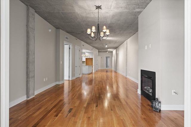 417 Frazier Ave Unit 303, Chattanooga, TN 37405 - unfurnished living room with a chandelier, wood finished floors, and a glass covered fireplace