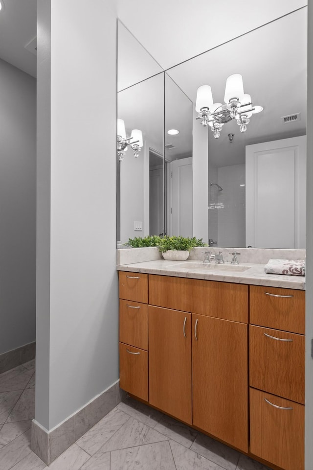 417 Frazier Ave Unit 303, Chattanooga, TN 37405 - bathroom with marble look tiles, vanity, a chandelier, and a shower