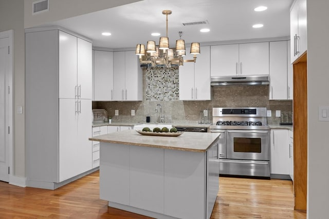 417 Frazier Ave Unit 303, Chattanooga, TN 37405 - kitchen featuring stainless steel gas stove, under cabinet range hood, light countertops, white cabinetry, and recessed lighting