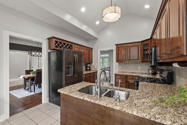 2386 Pleasant View Rd, Pleasant View, TN 37146 - kitchen with appliances with stainless steel finishes, a peninsula, light stone counters, decorative backsplash, and glass insert cabinets