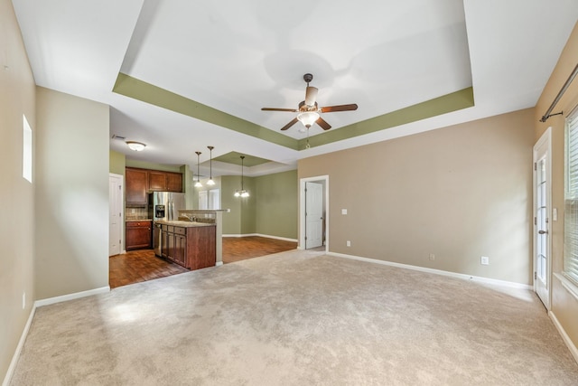 2438 Duxbury Dr, Columbia, TN 38401 - unfurnished living room featuring a tray ceiling, dark carpet, and ceiling fan