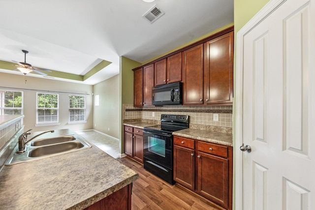 2438 Duxbury Dr, Columbia, TN 38401 - kitchen with black appliances, decorative backsplash, ceiling fan, wood finished floors, and a raised ceiling
