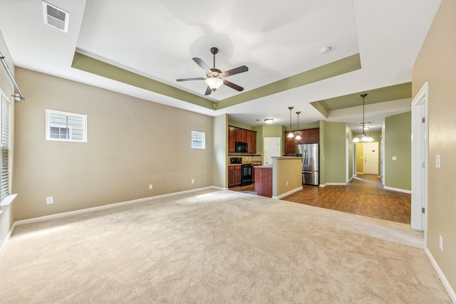2438 Duxbury Dr, Columbia, TN 38401 - unfurnished living room featuring a tray ceiling, dark colored carpet, and ceiling fan