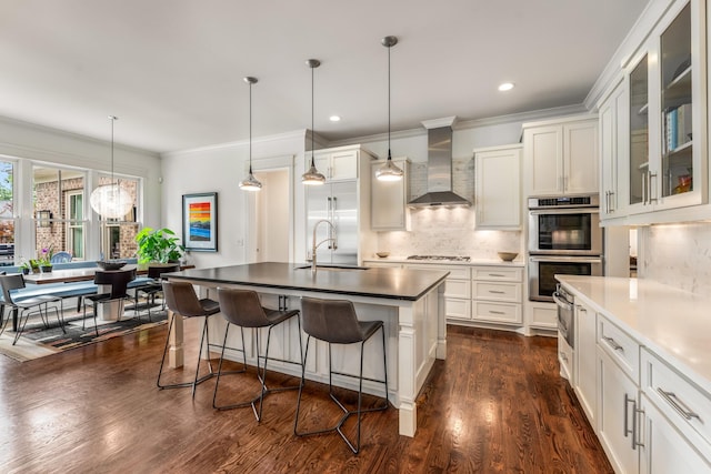 1727 Hillmont Dr, Nashville, TN 37215 - kitchen with wall chimney range hood, stainless steel double oven, white gas cooktop, decorative backsplash, and ornamental molding