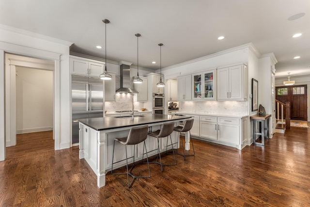 1727 Hillmont Dr, Nashville, TN 37215 - kitchen featuring wall chimney exhaust hood, stainless steel appliances, decorative backsplash, crown molding, and white cabinetry