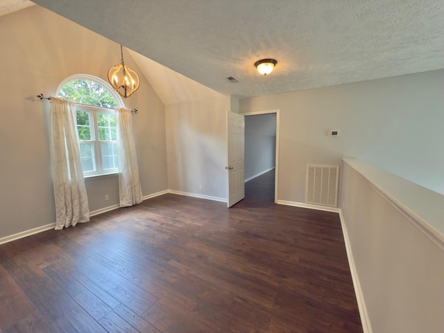 213 Ramsey Rd, Murfreesboro, TN 37127 - spare room featuring dark wood-type flooring, a chandelier, a textured ceiling, and lofted ceiling