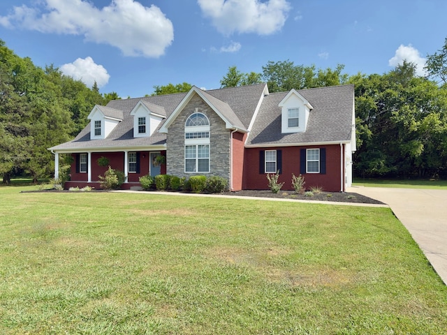 213 Ramsey Rd, Murfreesboro, TN 37127 - cape cod house with a front yard, concrete driveway, covered porch, stone siding, and roof with shingles