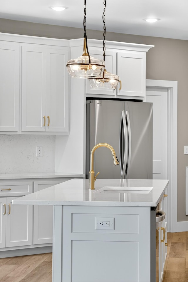 1263 N Sumner Rd, Bethpage, TN 37022 - kitchen featuring freestanding refrigerator, a kitchen island with sink, light countertops, white cabinetry, and decorative light fixtures