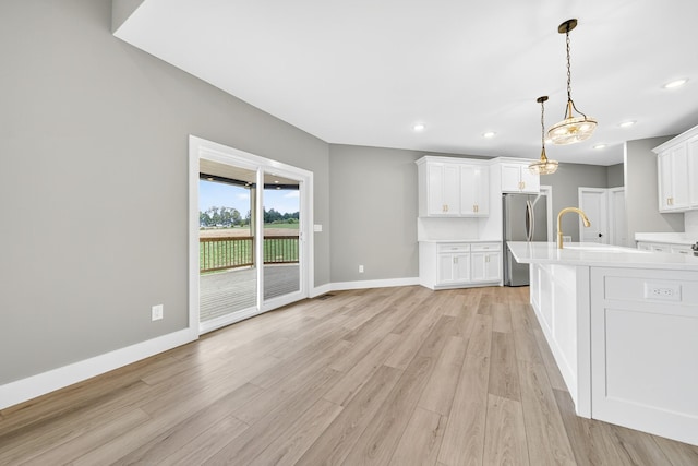 1263 N Sumner Rd, Bethpage, TN 37022 - kitchen with freestanding refrigerator, light countertops, light wood finished floors, white cabinetry, and pendant lighting