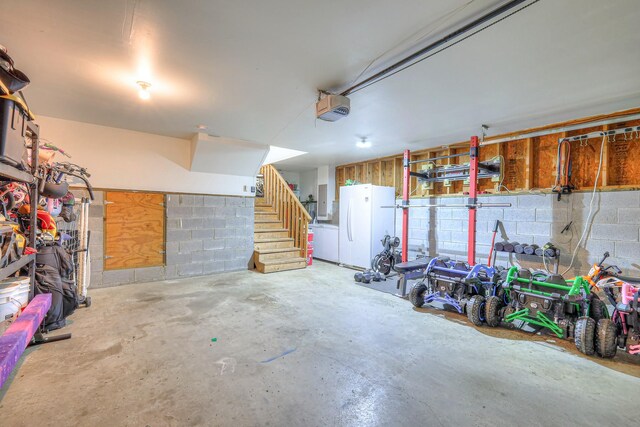 2808 Lafayette Dr, Thompsons Station, TN 37179 - garage featuring freestanding refrigerator, a garage door opener, and concrete block wall