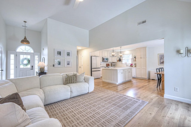 2808 Lafayette Dr, Thompsons Station, TN 37179 - living room with high vaulted ceiling, light wood-style flooring, healthy amount of natural light, ceiling fan, and a chandelier