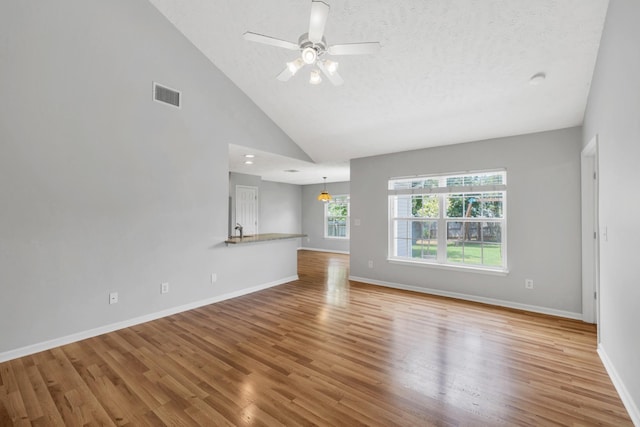 3313 Monoco Dr, Spring Hill, TN 37174 - unfurnished living room featuring wood finished floors, a ceiling fan, high vaulted ceiling, and a textured ceiling