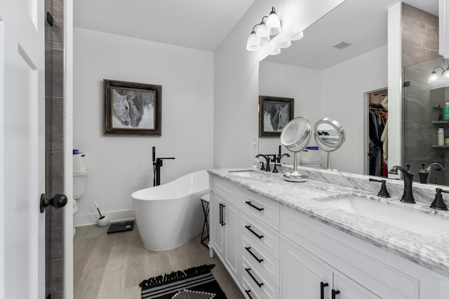1020 Loggins Rd, Charlotte, TN 37036 - full bathroom with double vanity, a stall shower, a spacious closet, wood finished floors, and a soaking tub
