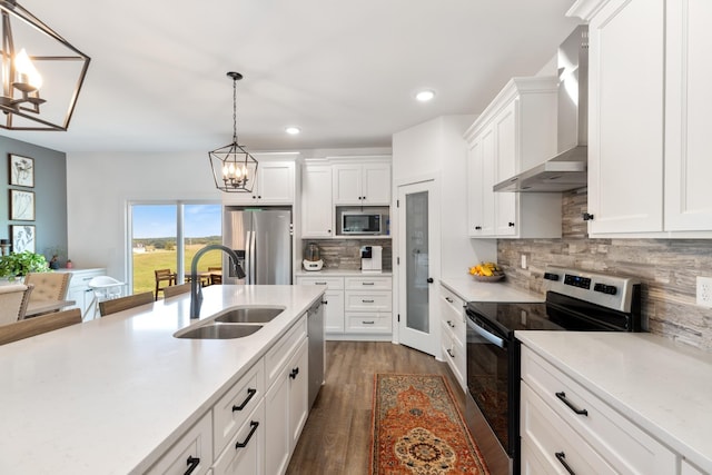 1020 Loggins Rd, Charlotte, TN 37036 - kitchen featuring appliances with stainless steel finishes, wall chimney range hood, a chandelier, light countertops, and recessed lighting
