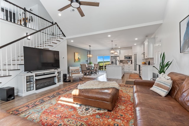 1020 Loggins Rd, Charlotte, TN 37036 - living area with stairway, a ceiling fan, light wood finished floors, high vaulted ceiling, and recessed lighting