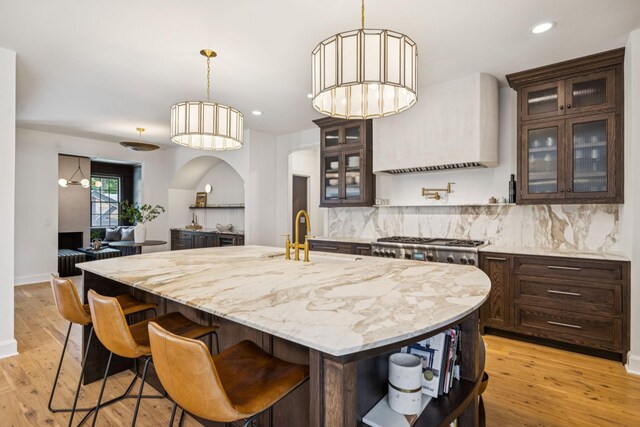 3404 Benham Ave, Nashville, TN 37215 - kitchen featuring open shelves, premium range hood, dark brown cabinetry, tasteful backsplash, and light wood-style floors