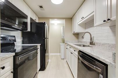 420 Elysian Fields Rd Unit E4, Nashville, TN 37211 - kitchen featuring black appliances, tasteful backsplash, white cabinets, and light wood finished floors