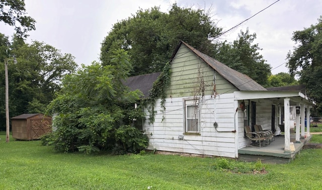 209 Olive St, Mount Pleasant, TN 38474 - view of home's exterior featuring a lawn, a shingled roof, a shed, and a porch