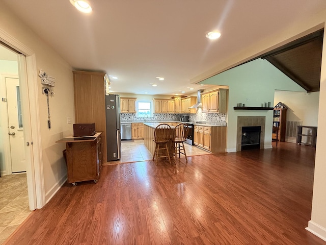 2680 Cedar Grove Rd, Lebanon, TN 37087 - kitchen featuring appliances with stainless steel finishes, wall chimney range hood, a center island, a breakfast bar area, and dark wood-style floors